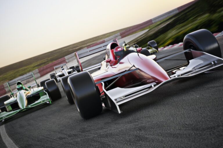 Red race car close up front view on a track leading the pack with motion Blur